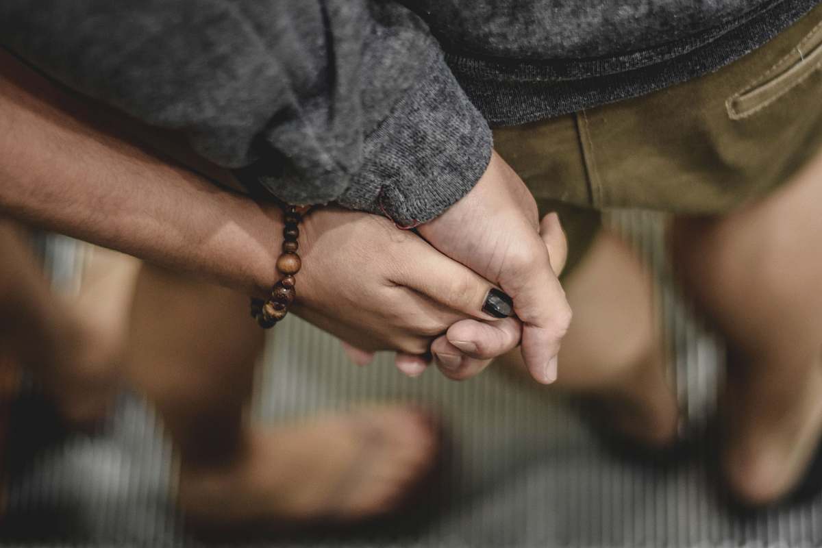 holding hands two person holding hands selective focus photography holding